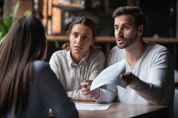 A young couple appear distressed as they engage in a dispute with a service provider