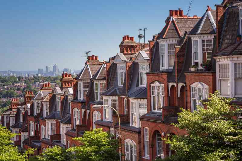 A row of traditional terraced houses on a hill overlooking the city, pictured on a sunny day